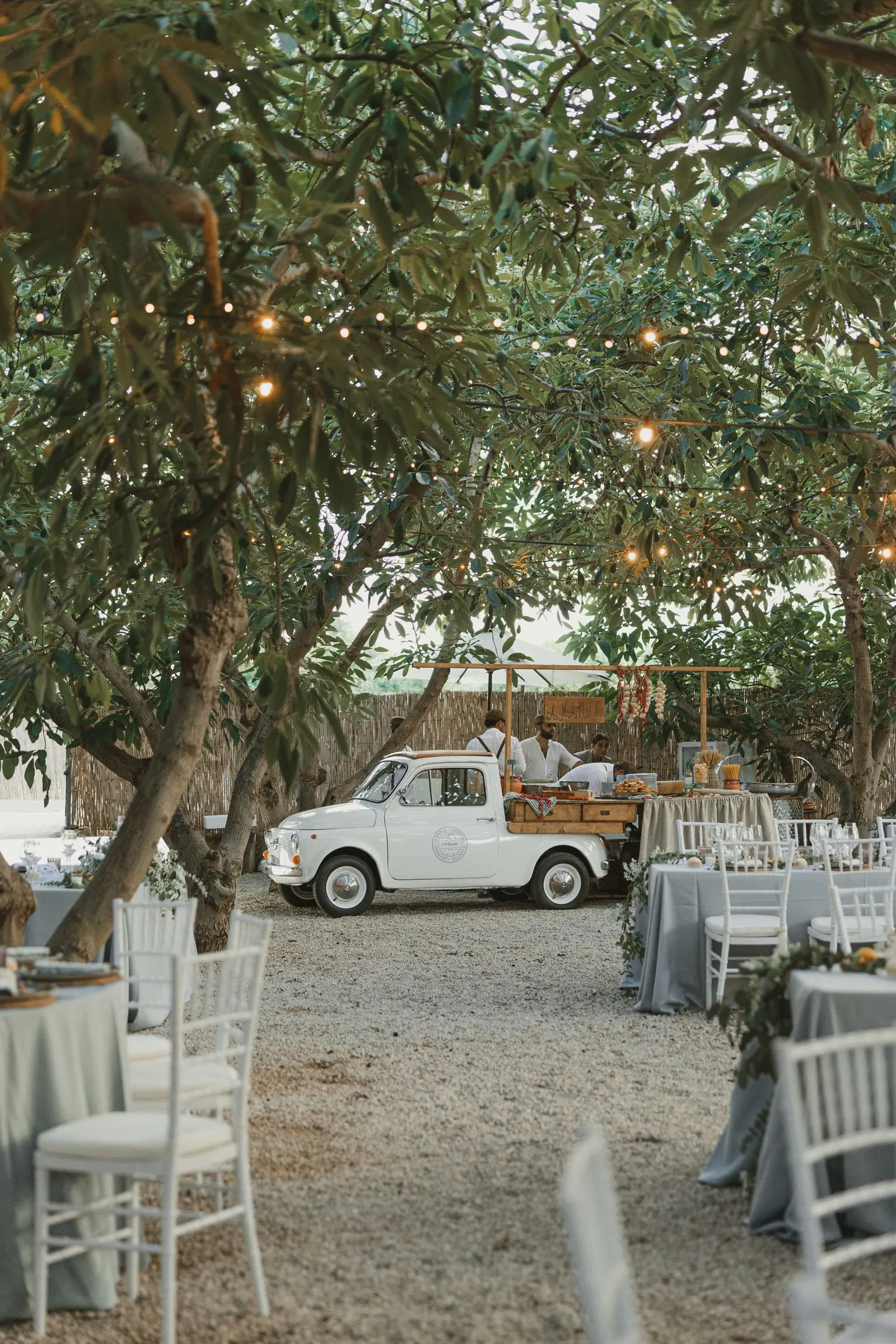 Food truck italiana de A’Napule junto a las mesas de una celebración en un jardín