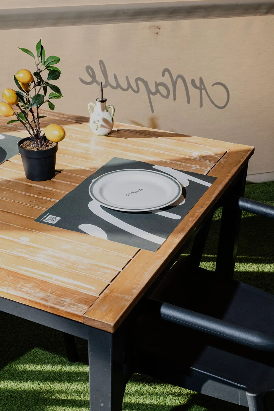 Mesa de la terraza preparada con plato blanco y cubiertos