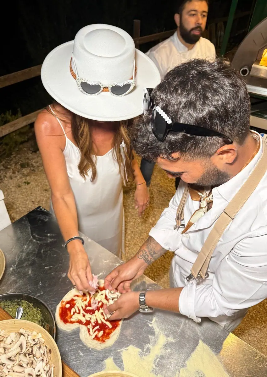 Una pareja corta una pizza durante su celebración
