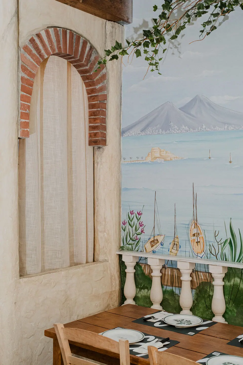 Mesa bajo el mural del Vesubio en el espacio Pergolado